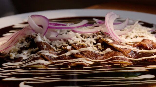 Las enmoladas con un platillo mexicano que representa su cocina. Son tortilla rellenas de carne, huevo &oacute; queso, ba&ntilde;adas en el delicioso y tradicional mole mexicano.