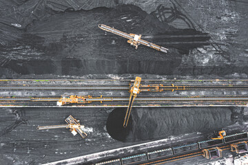 Aerial view of excavator and conveyor belt in coal storage. Coal transport and large warehouse
