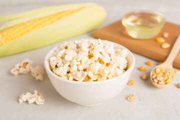 Prepared popcorn with ingredients on wooden table