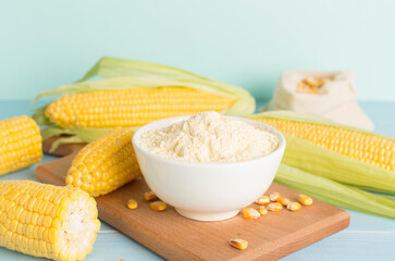 Corn flour with fresh cobs on wooden table