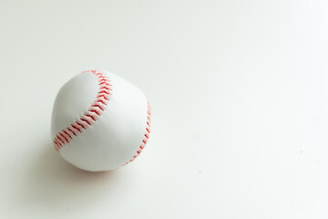 white baseball ball with red threads on white paper background