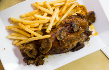 Oven baked pork knuckle with french fries and mushrooms. High quality photo