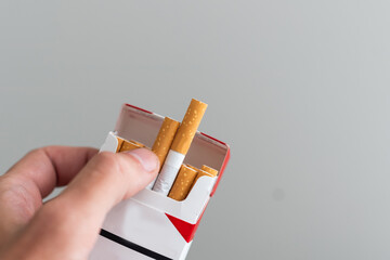 Pack of cigarettes in hand, isolated on white background