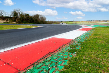 Motor sport asphalt race track and curbs with skid marks, low angle view