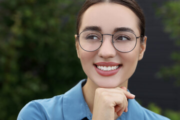 Portrait of beautiful woman in glasses on blurred background. Attractive lady smiling and posing...