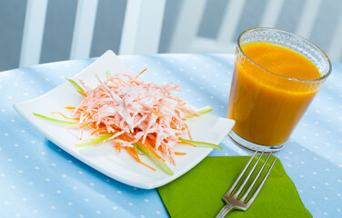 Light dietary breakfast of carrot salad and carrot juice