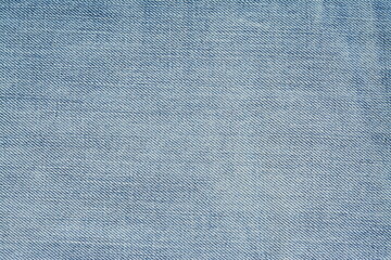 Background of washed light blue jeans. View from above
