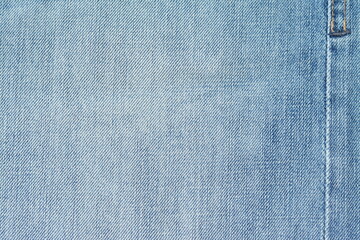 Background of washed light blue jeans with a seam. View from above