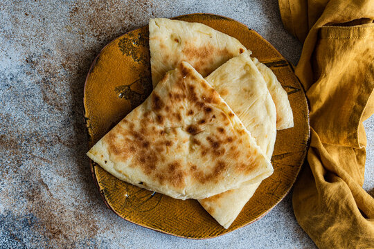 Overhead view of Georgian cheese bread slices (Imeruli khachapuri) on a plate