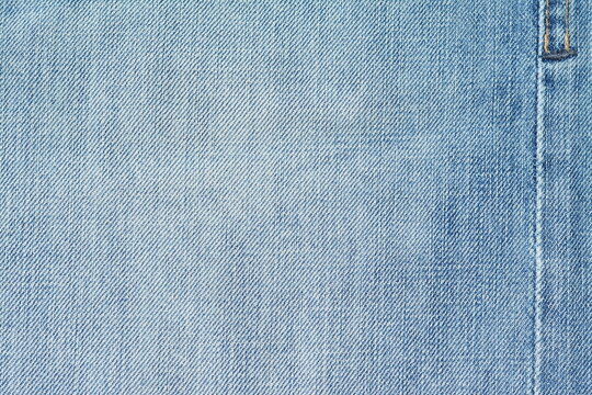 Background of washed light blue jeans with a seam. View from above