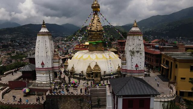 Aerial view of the popular Tibetan pilgrimage temple Swayambhu in Kathmandu city. Drone flight with a view of Buddha's eyes in Swayambhunath. Cinematic 4k footage.