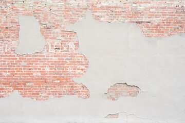 Empty, old brick wall texture.  Grungy, distressed painted brick surface. Red, stone wall with damaged plaster facade.  Abstract background with copy space.