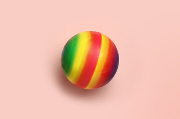 Bright rubber kids' ball on pink background, top view