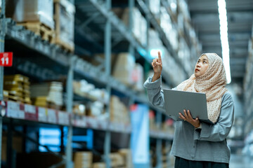 Portrait of Asian muslim female headscarf hijab holding computer laptop checklist product shelves...