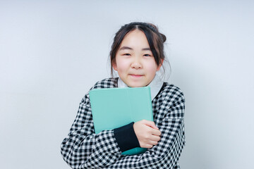 Obraz premium タブレットを抱えカメラ目線で微笑む女の子