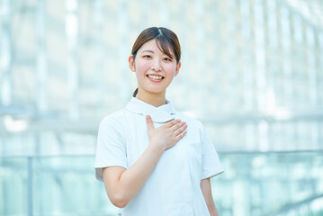 胸に手を当てるポーズをする白衣の女性