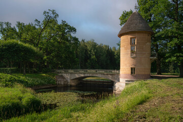 Slavyanka River and the Pill Tower Bridge in the Pavlovsk Palace and Park Complex on a sunny summer day, Pavlovsk, Saint Petersburg, Russia
