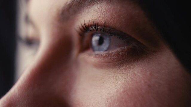 Front macro studio shot of woman smiling with close up on eyes and eyelashes - shot in slow motion