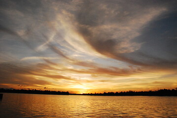 Scenic view dramatic beautiful sunset sky. Natural Sunset Sunrise on meadow silhouette shadow dark land. Vibrant dramatic sky on sunset, dawn, sunrise in Countryside. Landscape Colorful Sky At Sunset