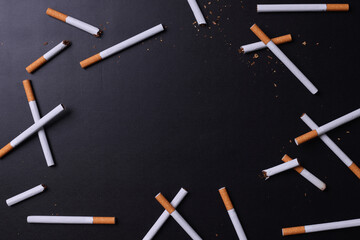 Top view of broken cigarettes with copy space for text or ads on black background. 
