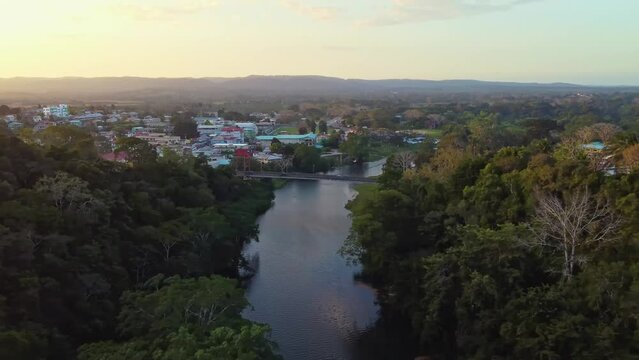 Aerial over the Macal River towards San Ignacio in Belize. Drone dolly forward shot