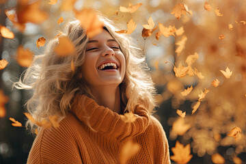 A girl in a warm sweater laughing while tossing leaves in the air.