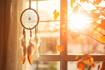 Dreamcatcher hanging by a window with the soft glow of golden hour sunlight 