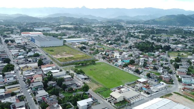 Football field in the Favelas of Rio de Janeiro with some female players - distant aerial drone shot