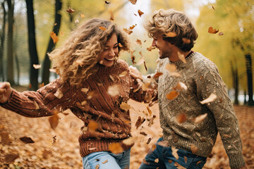 Two friends in cozy sweaters enjoying a leaf fight in a park.