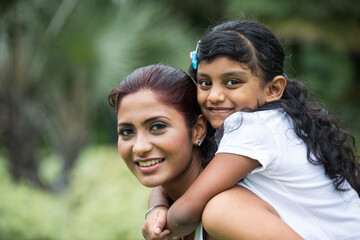 Fototapeta premium Happy Indian mum and her child playing outdoors