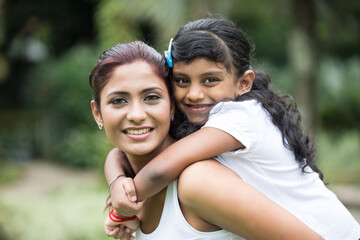 Fototapeta premium Happy Indian mum and her child playing outdoors