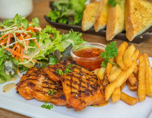 chicken steak with side dish in a white plate