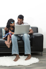 Indian dad and his daughter using a laptop together
