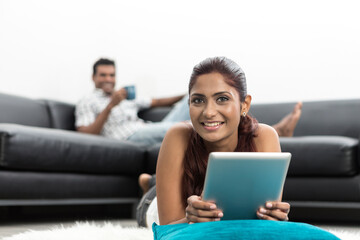 happy Indian woman using Digital Tablet at home