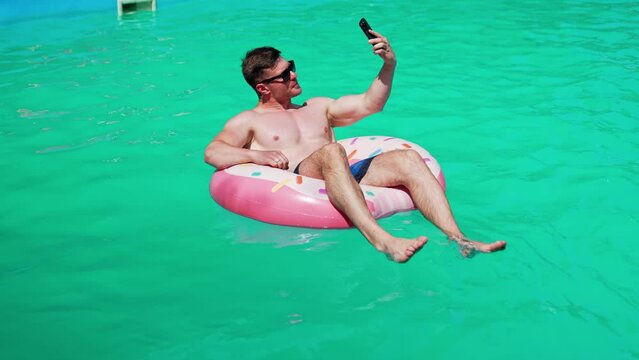 Summertime vaction man in pool having fun. Water fun in sunny summer day.
