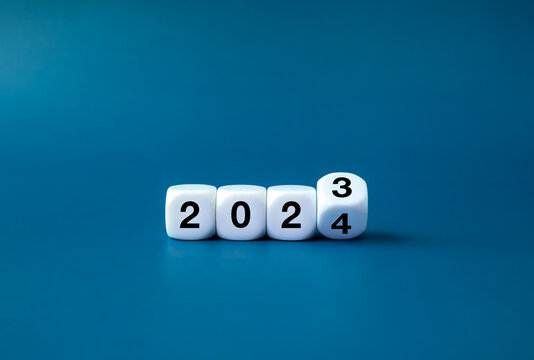 2024 happy new year with change to new era concepts. Flipping the 2023 to 2024 year calendar numbers on white dice, cube blocks isolated on dark blue banner background, minimalist simple style.