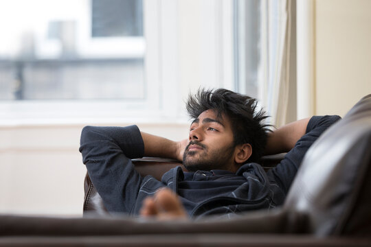 Indian Man Relaxing At Home On The Sofa.