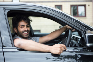 Happy Asian man in new car.