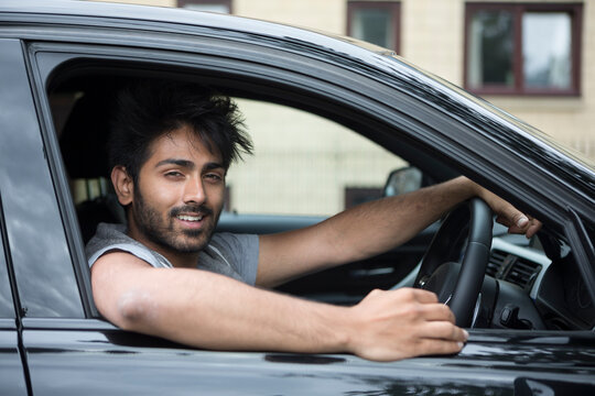 Happy Asian man in new car.
