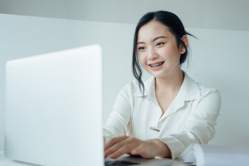 Asian woman rejoicing, say yes, looking happy and celebrating victory, champion dance, fist pump gesture, young happy cheerful cute business woman sitting indoors in office