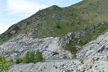 Road in the mountains of the Altai Mountains. Dangerous road, rockfall.