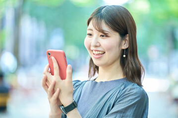 スマートフォンの画面を見る若い女性
