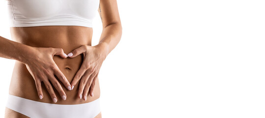 Middle part of female body with heart shape from hands. A woman in underwear symbolizes a healthy lifestyle, a healthy stomach, menstruation or pregnancy.