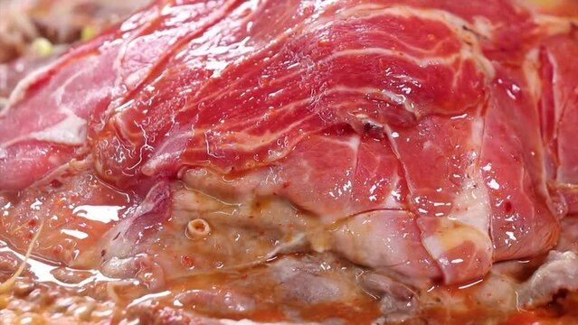 보글보글 끓고있는 불고기 전골에 쌓인 고기탑에 빨간 국물을 뿌리는 모습