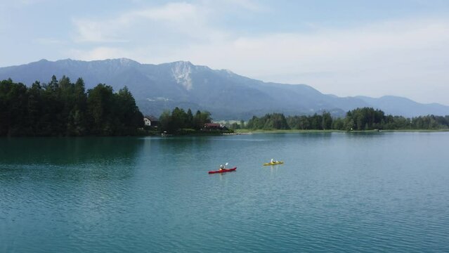 Nature's serenity: Kayaking on a lush lake, an adventure amidst green landscapes. Reconnect, paddle, embrace tranquility. Explore allure of untamed beauty. Enjoy the traveling holiday in austria.