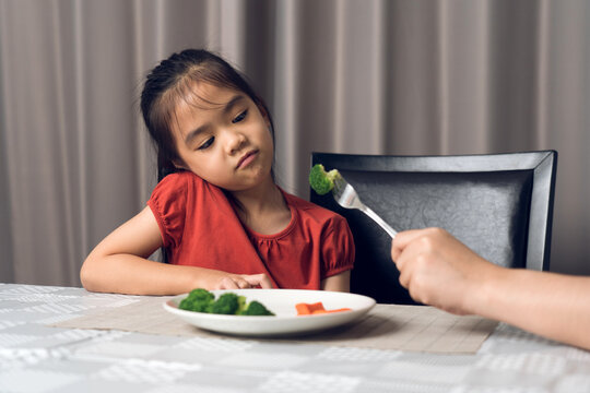 Little Cute Kid Girl Refusing To Eat Healthy Vegetables. Children Do Not Like To Eat Vegetables.