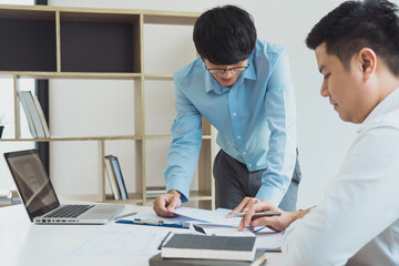 Fototapeta premium Two businessmen are analyzing company earnings figures at their desks.