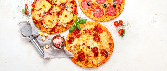 Different types of italian pizza on light background.