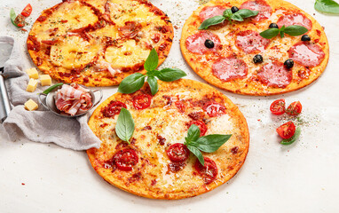 Different types of italian pizza on light background.