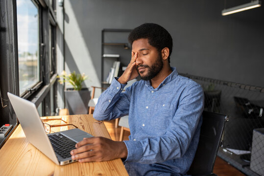 Tired businessman taking break on chair in office - Powered by Adobe